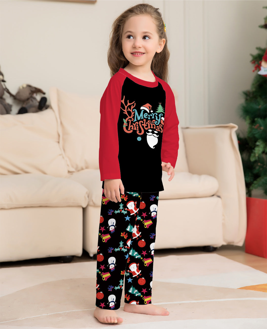 Child wearing Christmas-themed pajamas in a living room setting