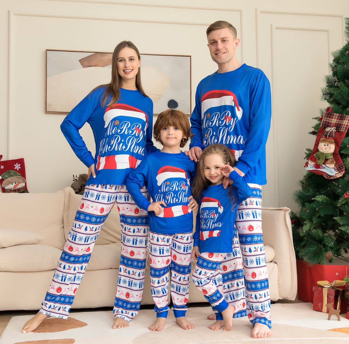 Family of four wearing matching Christmas pajamas in a living room with a decorated tree.