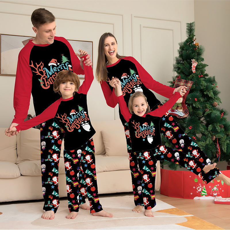 Family of four wearing matching Christmas pajamas in a living room with a decorated tree.