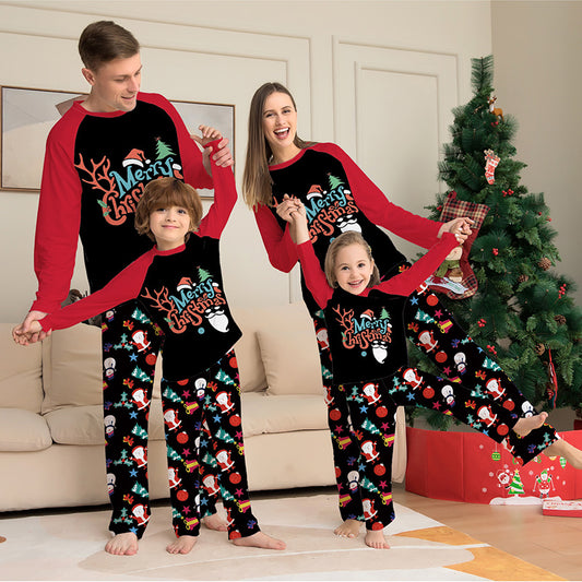 Family of four wearing matching Christmas pajamas in a living room with a decorated tree.