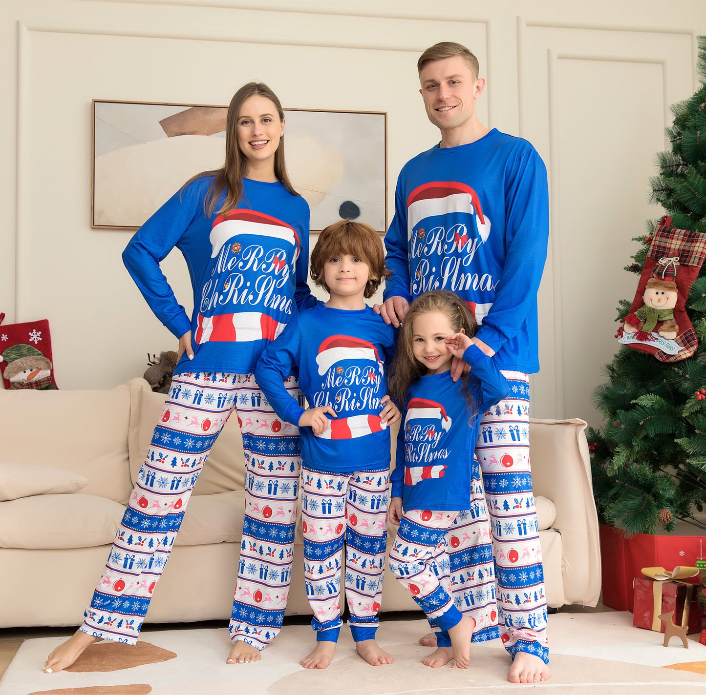Family of four wearing matching Christmas pajamas in a living room with a decorated tree.