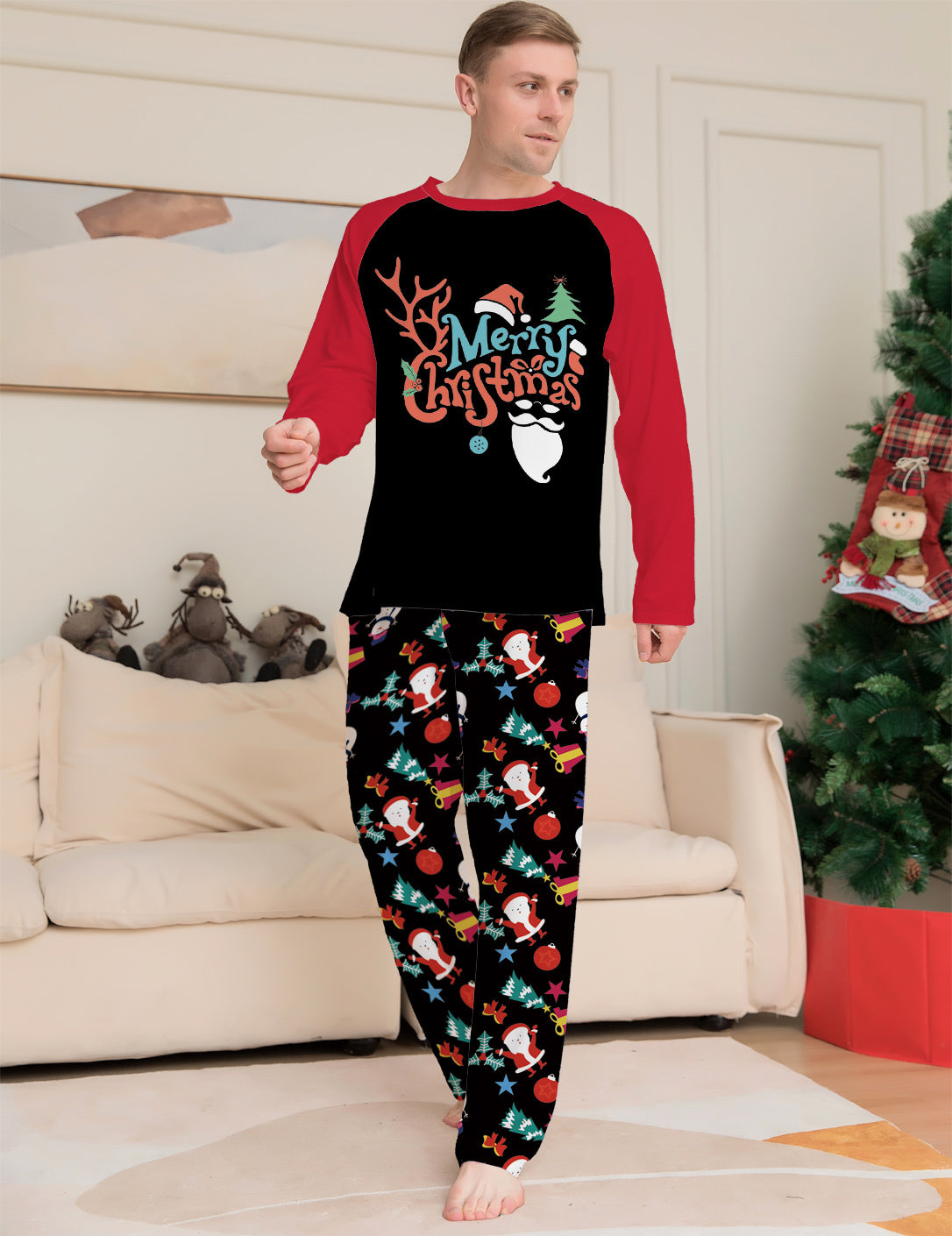 Man wearing Christmas-themed pajamas in a living room with a decorated tree.